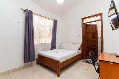 a small bedroom with a bed and a window at Bonsai Villa in Nairobi