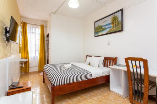 a small bedroom with a bed and a chair at Bonsai Villa in Nairobi