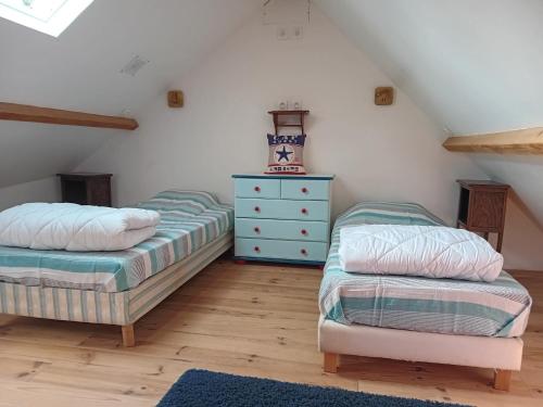 a attic bedroom with two beds and a dresser at La Goélette Beau duplex A 150 m du centre ville et 400m de la plage de l'écluse in Dinard