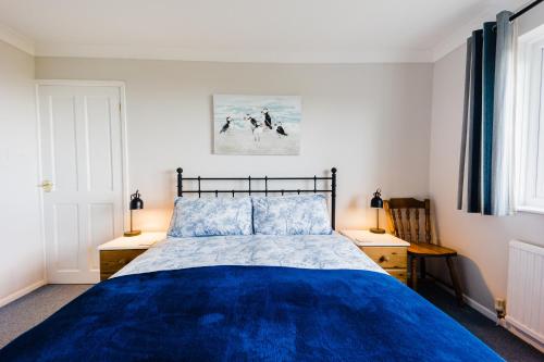 una camera con letto blu e due comodini di The Willows Dinas Cross a Dinas