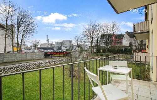 a balcony with a table and chairs and a train at BEGE APARTMENTS: FIRM RELAX in Mettmann