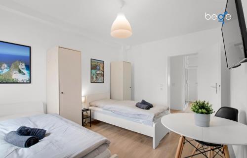a small room with two beds and a table at BEGE APARTMENTS: FIRM RELAX in Mettmann