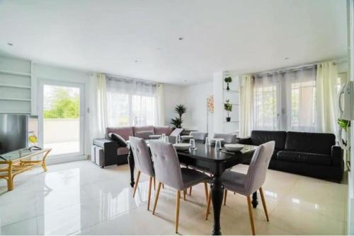 un salon avec une table et des chaises noires dans l'établissement Appartement Disneyland 5km spacieux et lumineux, à Montry