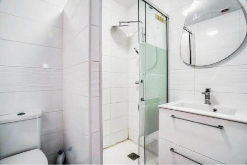 une salle de bain avec toilettes, lavabo et miroir dans l'établissement Appartement Disneyland 5km spacieux et lumineux, à Montry