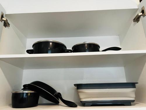 a shelf with pots and pans in a kitchen at KENNA'S NOOK in Butuan