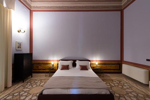 1 dormitorio con 1 cama grande y 2 almohadas en Palazzo Francesco Grassi, en Aradeo