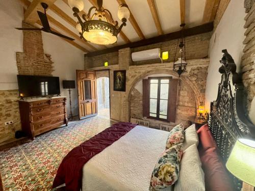 ein Schlafzimmer mit einem großen Bett und einem Kronleuchter in der Unterkunft Oliva Courtyard Guesthouse in Oliva