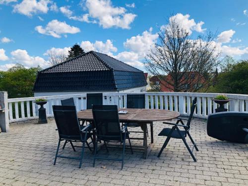 Une table et des chaises en bois sont disponibles sur la terrasse. dans l'établissement aday - Nice and cozy place, à Aalborg