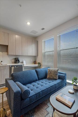 a living room with a blue couch and a table at CozySuites Modern SDO, Lawrenceville in Pittsburgh