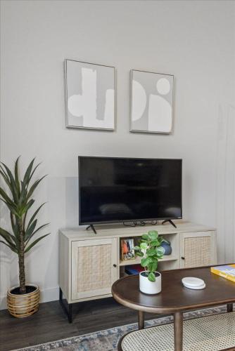 a living room with a tv and a table at CozySuites Modern SDO, Lawrenceville in Pittsburgh