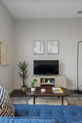 a living room with a coffee table and a tv at CozySuites Modern SDO, Lawrenceville in Pittsburgh