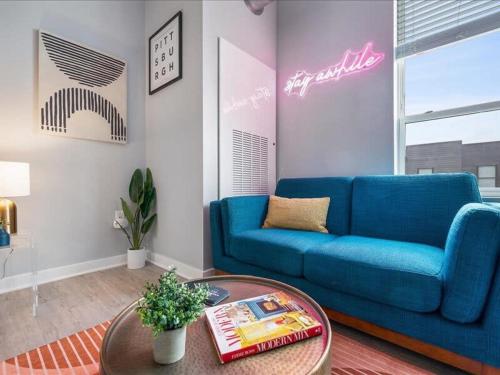 a living room with a blue couch and a table at CozySuites Boutique SDO, Lawrenceville in Pittsburgh