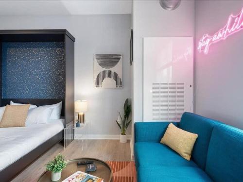 a living room with a bed and a blue couch at CozySuites Boutique SDO, Lawrenceville in Pittsburgh