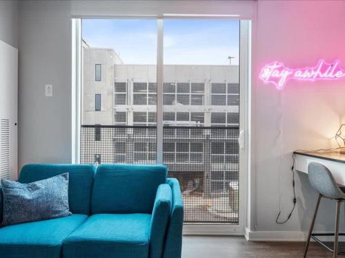 a living room with a blue couch in front of a window at CozySuites Trendy SDO, Lawrenceville in Pittsburgh