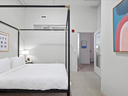 um quarto com uma grande cama branca num quarto em CozySuites Roomy 1BR, Downtown Pittsburgh em Pittsburgh
