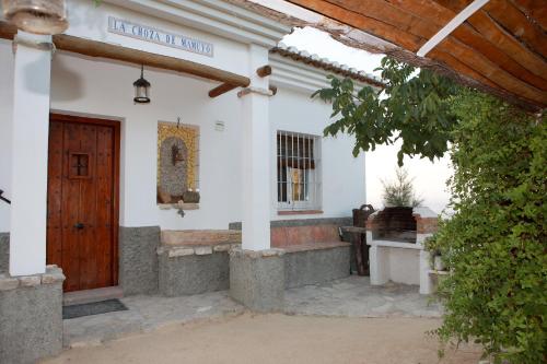 a white church with a wooden door and a window at La Choza De Mamuyo in Montefrío