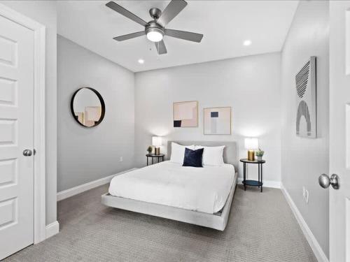 a white bedroom with a bed and a ceiling fan at CozySuites Modern 1BR, PPG Paints Arena, Pitts in Pittsburgh