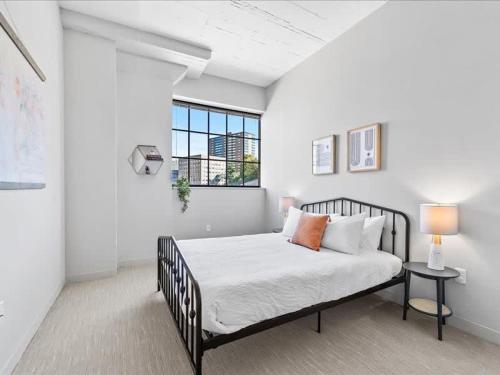 匹茲堡的住宿－CozySuites Trendy 1BR, Downtown Pittsburgh，一间卧室设有一张床和一个窗口