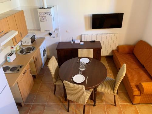 cocina pequeña con mesa, sillas y sofá en Apartamentos Jaca Mirador de Badaguas 3000, en Badaguás
