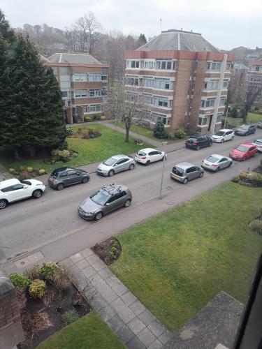 un grupo de coches estacionados en una calle de la ciudad en Open space studio in Shawlands en Glasgow