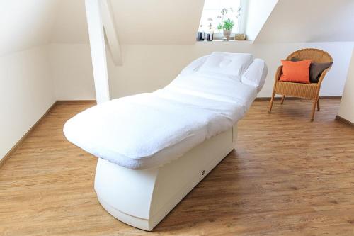 a bed with white sheets on top of it in a room at Hotel Deutschherrenhof in Zeltingen-Rachtig