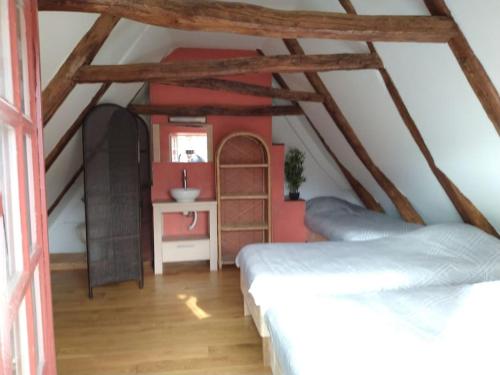 Cette chambre mansardée comprend deux lits et une commode. dans l'établissement Maison coeur de causse, à Fontanes-du-Causse