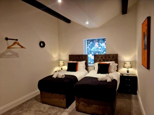 two twin beds in a room with two lamps at The Hamilton luxury holiday let's- Holly Barn in Scorton