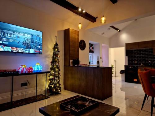 a living room with a christmas tree and a tv at The Hamilton luxury holiday let's- Holly Barn in Scorton