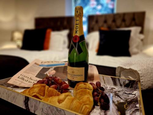 a bottle of wine and a tray of bread and grapes at The Hamilton luxury holiday let's- Holly Barn in Scorton