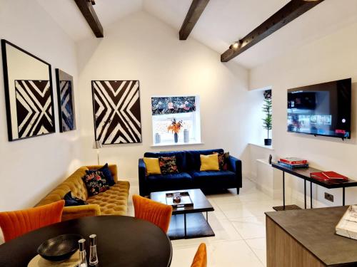 a living room with two couches and a table at The Hamilton luxury holiday let's- Holly Barn in Scorton