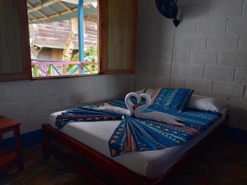 a bed with towels on it with a window at Casa hostal playa coral in Capurganá
