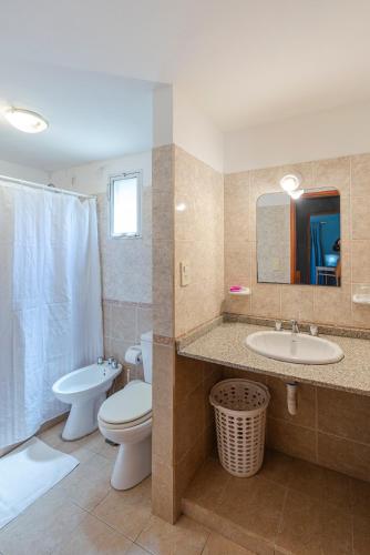 a bathroom with a toilet and a sink and a mirror at Cerro de los Duendes in Santa Rosa de Calamuchita