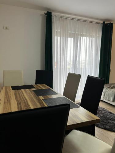 uma mesa de jantar com cadeiras e uma grande janela em Chisoda em Chişoda