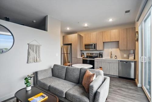 a living room with a couch and a kitchen at CozySuites Roomy 1BR, Lawrenceville in Pittsburgh