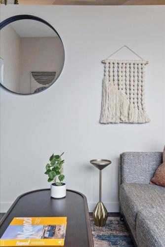 a living room with a table and a mirror at CozySuites Roomy 1BR, Lawrenceville in Pittsburgh