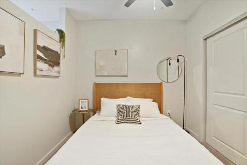 Schlafzimmer mit einem großen weißen Bett mit einem Kopfteil aus Holz in der Unterkunft CozySuites Roomy 1BR, Lawrenceville in Pittsburgh