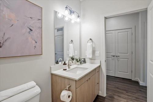 ein weißes Bad mit einem Waschbecken und einem WC in der Unterkunft CozySuites Roomy 1BR, Lawrenceville in Pittsburgh