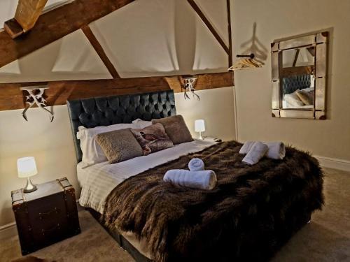 una camera da letto con un letto grande con due asciugamani sopra di The Hamilton luxury holiday let's- The Coach House with hot tub a Scorton