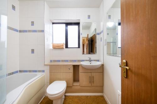 een badkamer met een toilet, een wastafel en een bad bij Amazing 2Bed in Canary Wharf in Londen