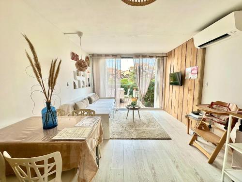 un salon avec une table et un canapé dans l'établissement Appartement * Palavas-les-flots * Piscine, à Palavas-les-Flots