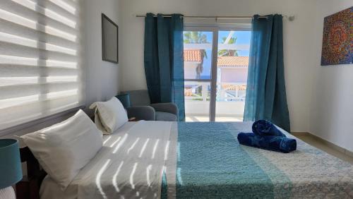 Schlafzimmer mit einem Bett und einem Fenster mit Aussicht in der Unterkunft Ocean Teal Villa Marazul in Westpunt