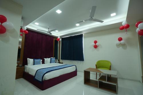 een slaapkamer met een bed en een stoel en rode ballonnen bij Hotel Raison Inn Bechraji in Kalri