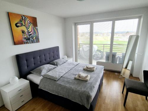 ein Schlafzimmer mit einem Bett mit zwei Handtüchern darauf in der Unterkunft THE BIG SPACE - Apartmaji PANONIA in Moravske-Toplice
