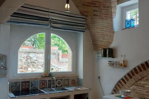 a kitchen with a sink and a window at La Cantina: cosy stylish vaults in Villalfonsina