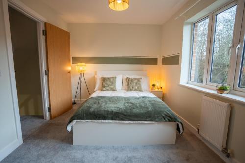 a bedroom with a large bed and two windows at Apple Tree in Redhill