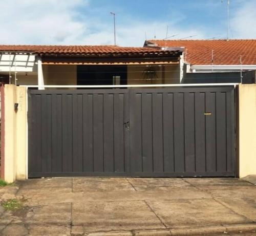 una puerta de garaje negra delante de una casa en Casa Inteira Próxima ao Centro / 4 Suítes. en Londrina