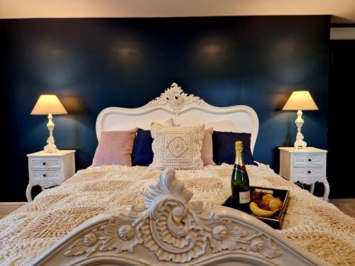 een slaapkamer met een wit bed en een fles champagne bij Hamilton-The Alexander suite luxury holiday let's in Scorton