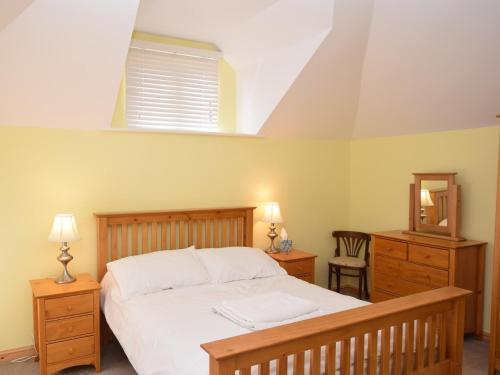 a bedroom with a bed and a dresser and a mirror at 2 Bed in Wroxham 29570 in Worstead