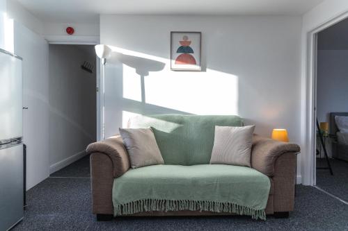 a living room with a green couch and a window at May Disc - Long Stay - Contractors in Bristol