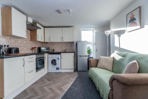 ein Wohnzimmer mit einem Sofa und einer Küche in der Unterkunft May Disc - Long Stay - Contractors in Bristol